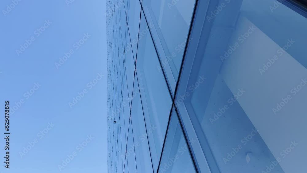 Building reflected on glass skyscraper in Paris, grey skyscraper in Paris, open glass at left, blue sky and reflections. Wide Shot. Building reflected on glass skyscraper in Paris, grey skyscraper in Paris, open glass at left, blue sky and reflections. Wide Shot.