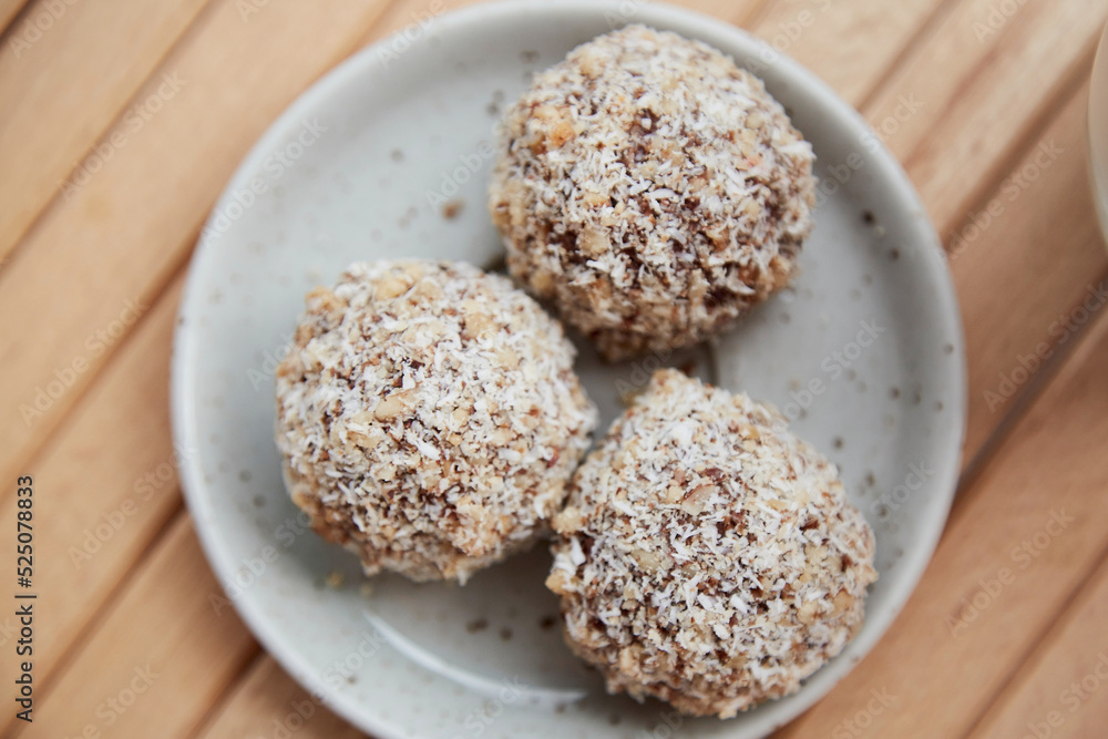 Vegan handmade gluten and sugar free delight - natural sweets balls on the wooden table close up. Healthy dessert. Raw food. Vegan handmade gluten and sugar free delight - natural sweets balls on the wooden table close up. Healthy dessert. Raw food.