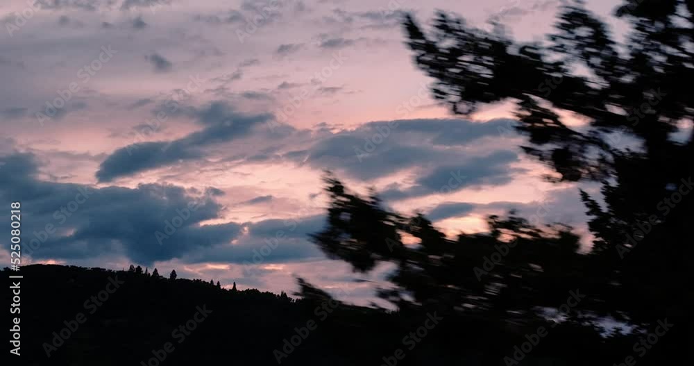 Aerial on zoom lens of sunset over mountains as pine trees flys past in the foreground. Aerial on zoom lens of sunset over mountains as pine trees flys past in the foreground.