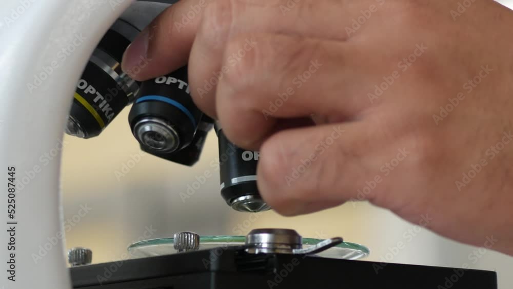 A hand using microscope in labotary science closeup research, Focus on microscope, Research and testing concept. A hand using microscope in labotary science closeup research, Focus on microscope, Research and testing concept.
