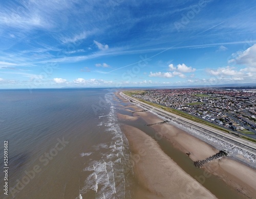Aerial view of the coast with sea and blue sky and buildings and houses. Taken in Fleetwood Lancashire England. 