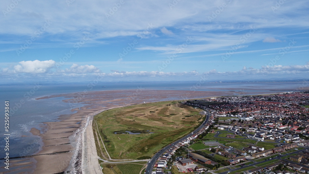 Aerial view of the coast with  sea and blue sky and buildings and houses. Taken in Fleetwood Lancashire England. 