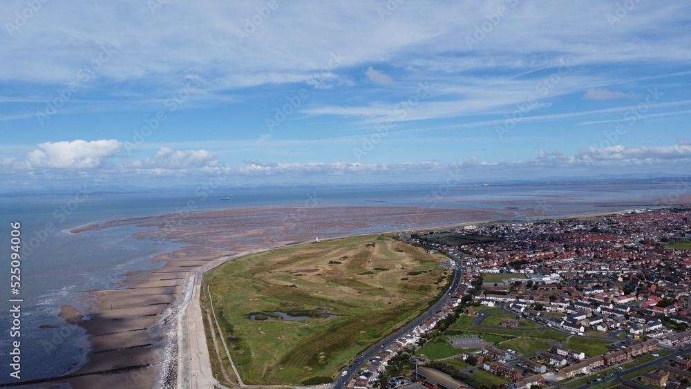 Aerial view of the coast with  sea and blue sky and buildings and houses. Taken in Fleetwood Lancashire England. 