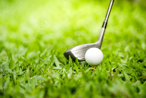golf club hitting a golf ball on green grass