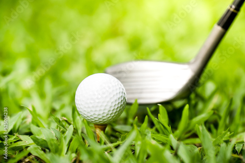 golf club hitting a golf ball on green grass