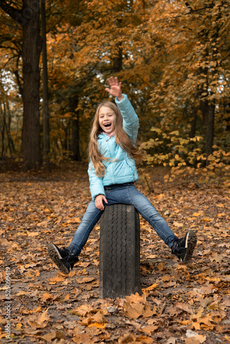 beautiful girl with long blonde hair having fun in autumn park