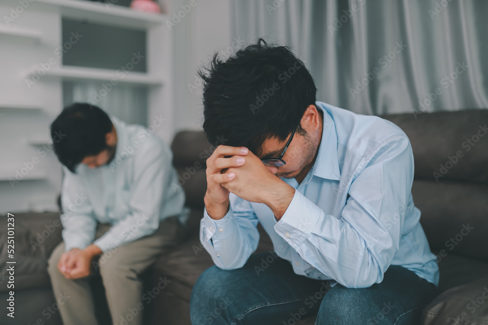 Homosexual male express sad or bad emotion from arguement or controversial problem. on sofas inside their homes, LGBTQ concept. Homosexual male express sad or bad emotion from arguement or controversial problem. on sofas inside their homes, LGBTQ concept.