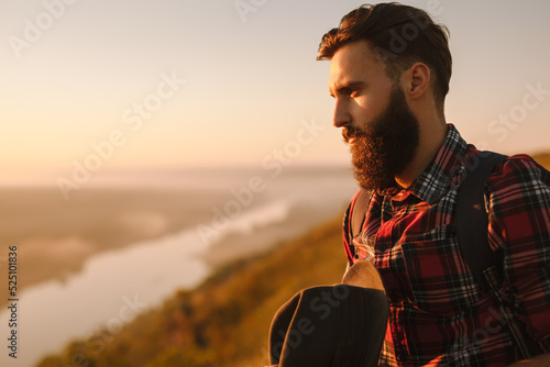 Bearded male traveler admiring river