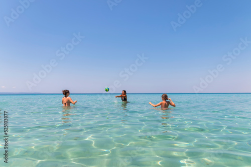Happy teenagers  playing volleyball in water at the beach.Traveling, vacation and fun © Jelena