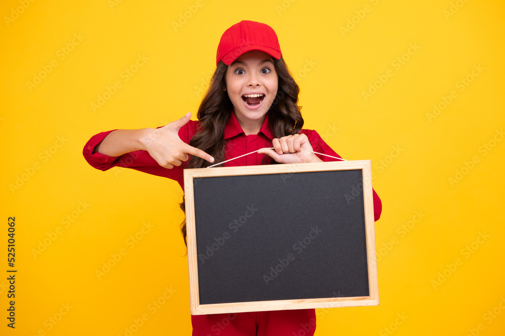 Excited child girl in red uniform and cap. Teenage girl hold blackboard isolated on yellow background. Copy space on empty board, mock up. Happy face, positive and smiling emotions of teenager girl. Excited child girl in red uniform and cap. Teenage girl hold blackboard isolated on yellow background. Copy space on empty board, mock up. Happy face, positive and smiling emotions of teenager girl.