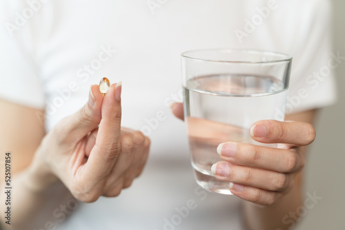 close up person pouring multivitamin capsules to her hands photo