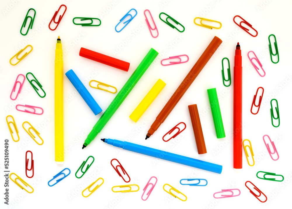 school background wallpaper with paper clips and colored felt-tip pens close-up on a white background for design school background wallpaper with paper clips and colored felt-tip pens close-up on a white background for design