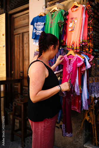 A young woman looking at clothes at street market.