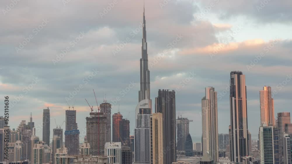 Panoramic skyline of Dubai downtown district with business bay night to day transition timelapse. Aerial view of many modern skyscrapers before sunrise. United Arab Emirates. Panoramic skyline of Dubai downtown district with business bay night to day transition timelapse. Aerial view of many modern skyscrapers before sunrise. United Arab Emirates.