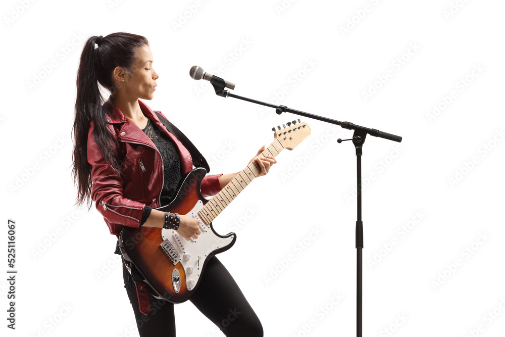 Young female musician with a guitar singing on a microphone