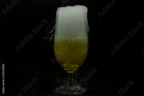 Bubbles foam and white smoke by cooling dry ice from beer contained in glass fancy drink for Halloween party photo