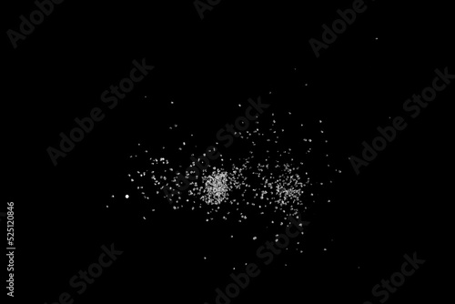 Sifting white caster sugar over black background. Isolated.