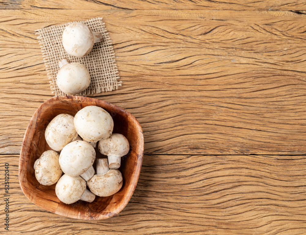 Paris mushrooms in a bowl over wooden table with copy space Paris mushrooms in a bowl over wooden table with copy space