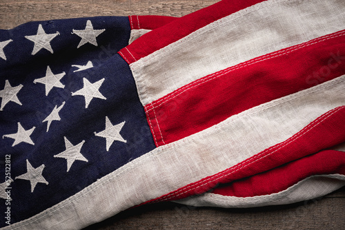 Vintage American flag draped across a rustic wooden background