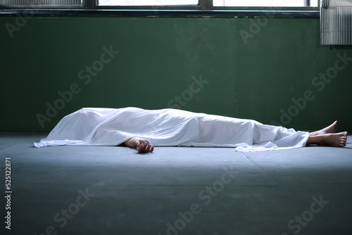 Dead woman lying down under white cloth covered death body from murder at house of victim.
