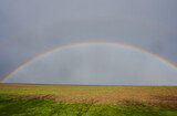 rainbow in the field,a rainbow appeared in the sky in the field in spring
