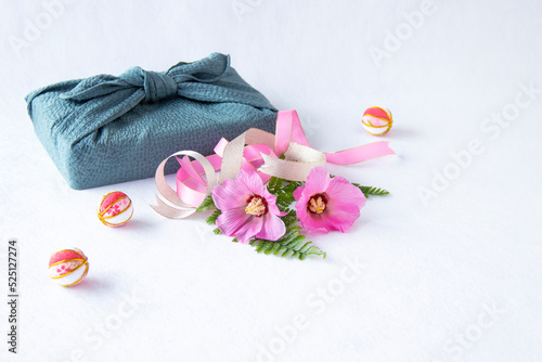 Fototapeta Naklejka Na Ścianę i Meble -  風呂敷包みとピンクの芙蓉の花とリボンと手毬（白バック）