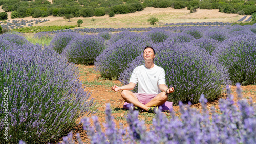 A man conducts meditation in nature in a lavender field