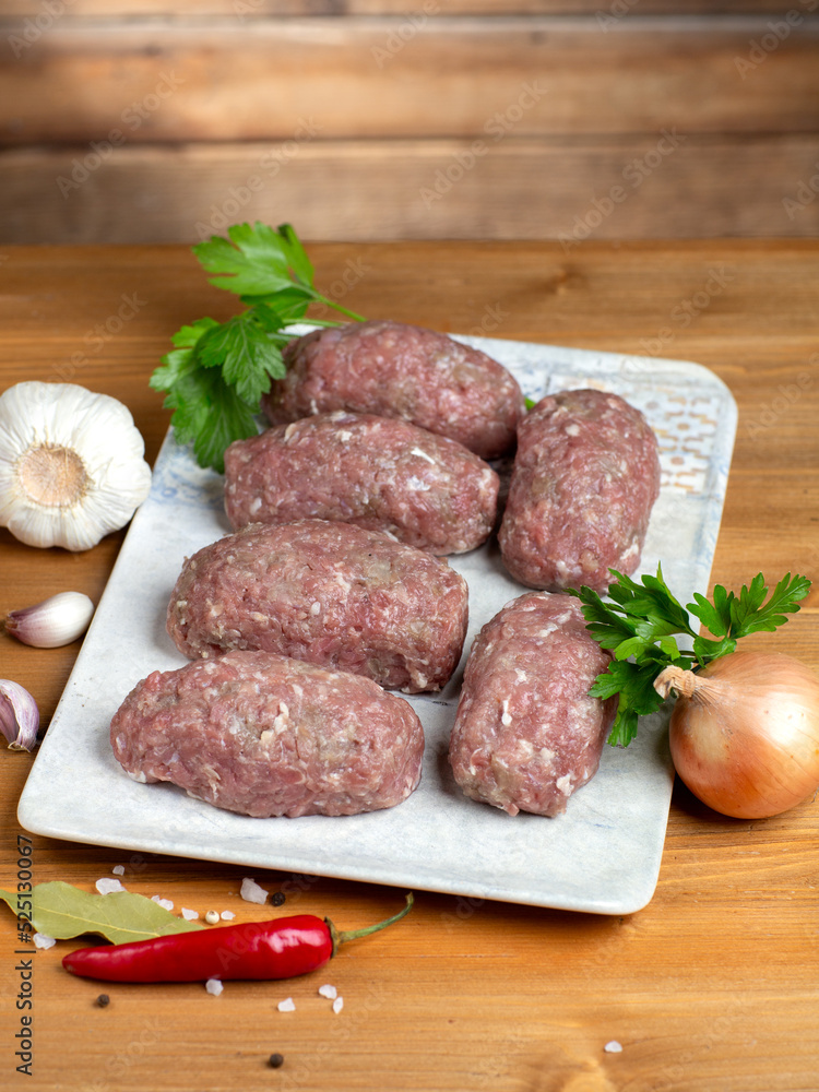 Turkey raw meatballs with vegetables on plate on wooden background. Turkey raw meatballs with vegetables on plate on wooden background.