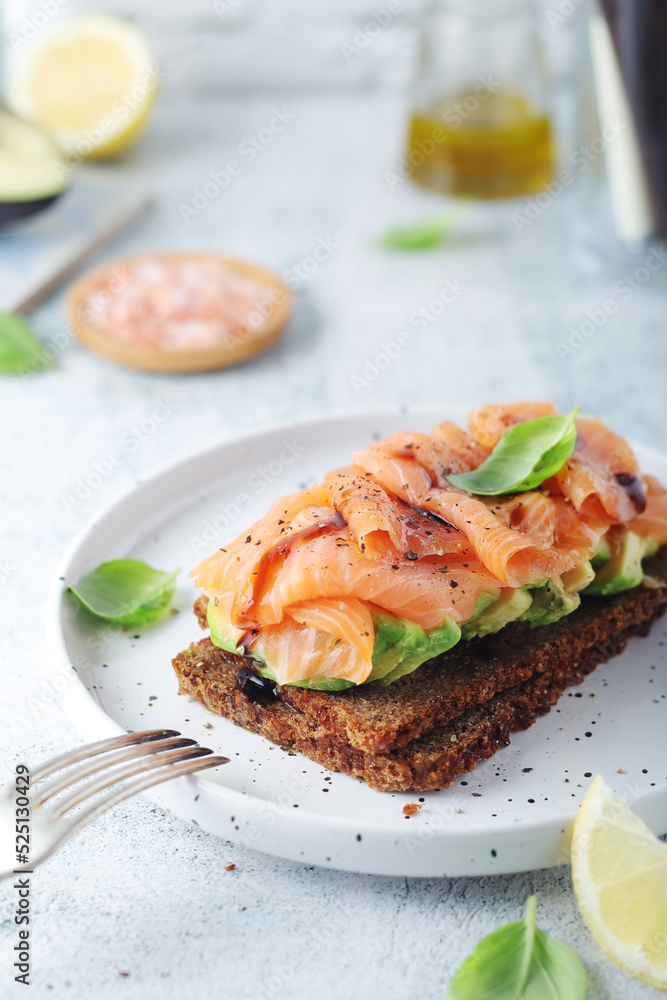 A rye bread sandwich with avocado and salmon