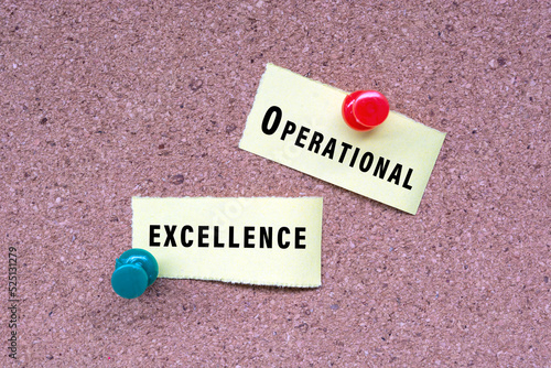 Operational excellence words on stick note and pinned to a cork notice board.