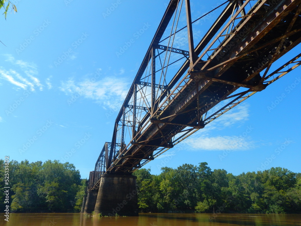 Fototapeta premium Beautiful rusted abandoned train bridge ruin crosses over the Altamaha River in South Georgia