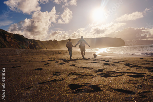 Couple walking on the beach with dog, Azores