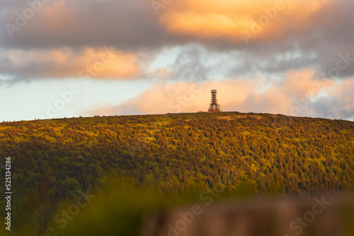 Fototapeta Naklejka Na Ścianę i Meble -  Poland, the Sudetes Mountains, mountain landscape in the Snieznik Massif, an observation tower under construction on top of the Snieznik Mountain. The summit is illuminated by the setting sun.