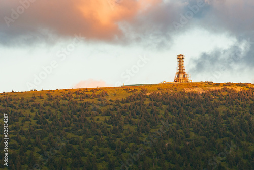 Fototapeta Naklejka Na Ścianę i Meble -  Poland, the Sudetes Mountains, mountain landscape in the Snieznik Massif, an observation tower under construction on top of the Snieznik Mountain. The summit is illuminated by the setting sun.