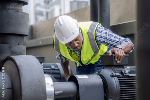 Engineer inspects a large industrial centrifugal pump. photo