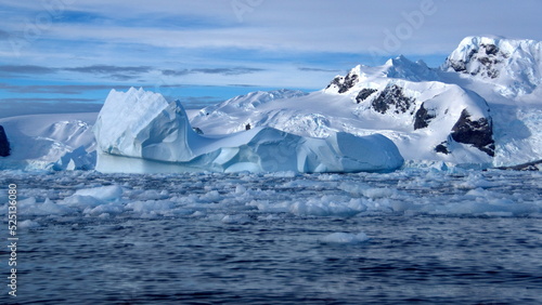 Icebergs floating in the bay, at the base of a snow covered mountain, at Cierva Cove, Antarctica