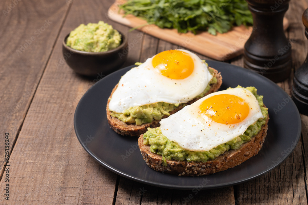 Two avocado open sandwiches with egg. Keto and diet concept. Healthy toast food for breakfast. Two avocado open sandwiches with egg. Keto and diet concept. Healthy toast food for breakfast.