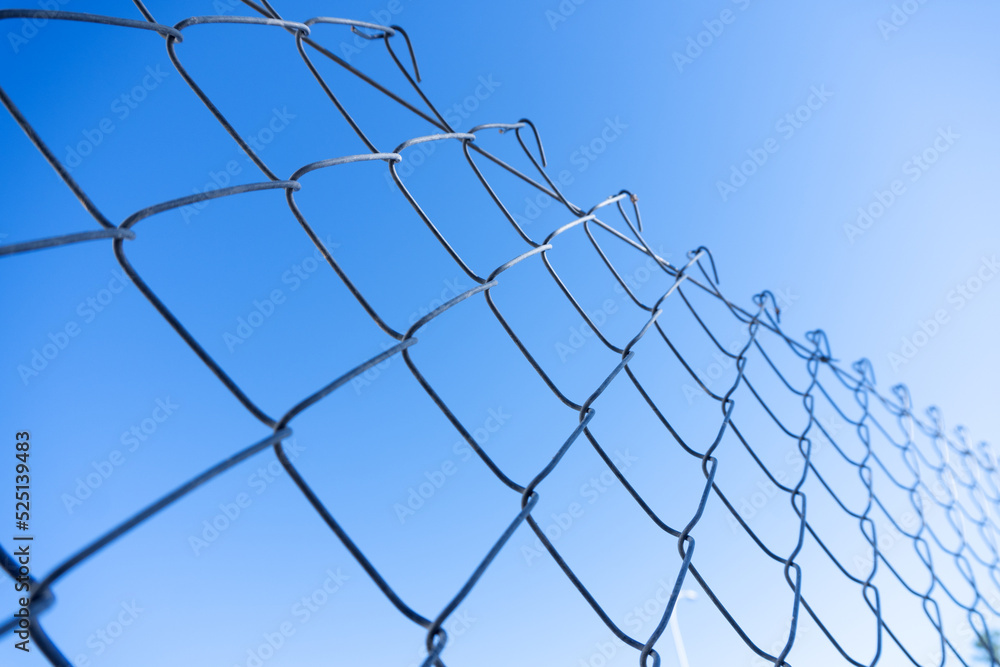 cyclone fence detail with blue sky cyclone fence detail with blue sky