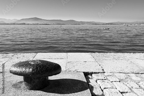 An iron bollard on a cobbled pier on the coast of Santander