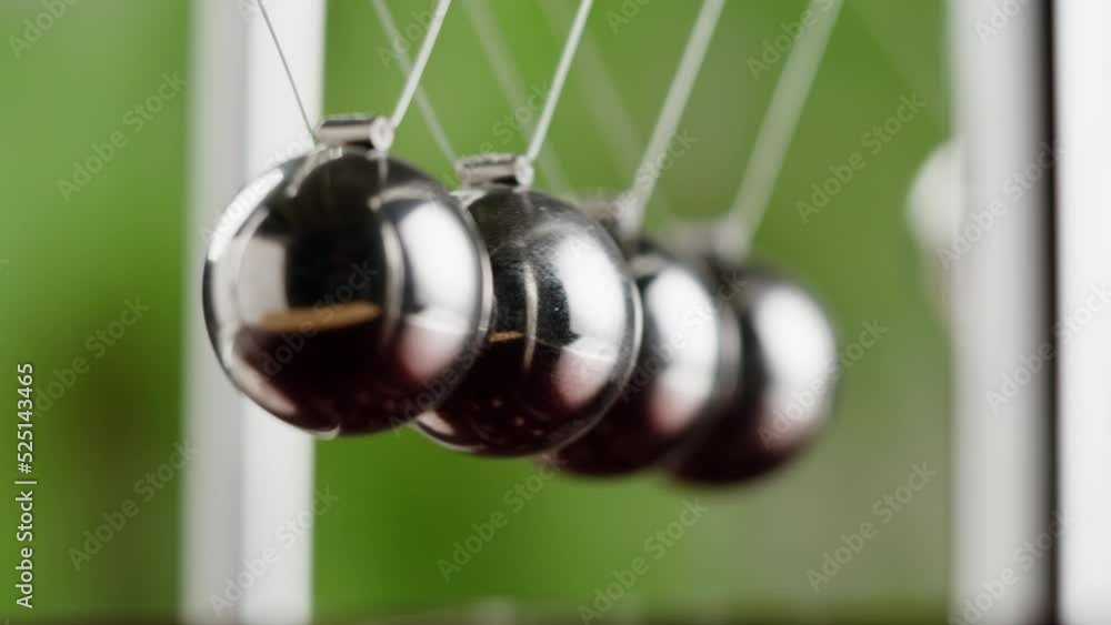 Newton balls close-up, five metallic pendulums colliding, cradle. Physics and science concept. Newton balls close-up, five metallic pendulums colliding, cradle. Physics and science concept.