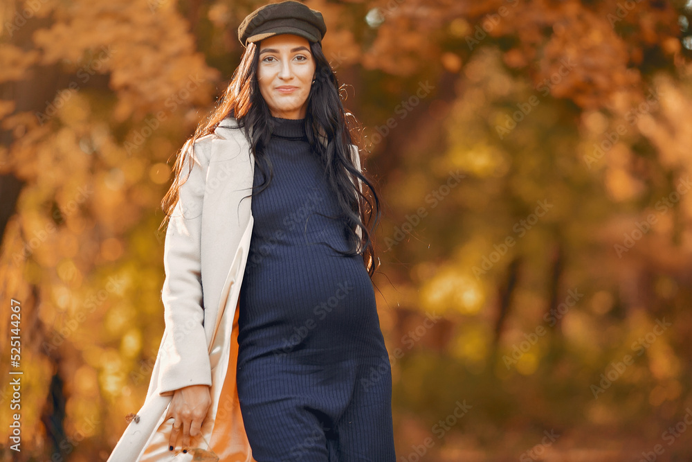 Pregnant woman in a brown coat in a autumn park Pregnant woman in a brown coat in a autumn park