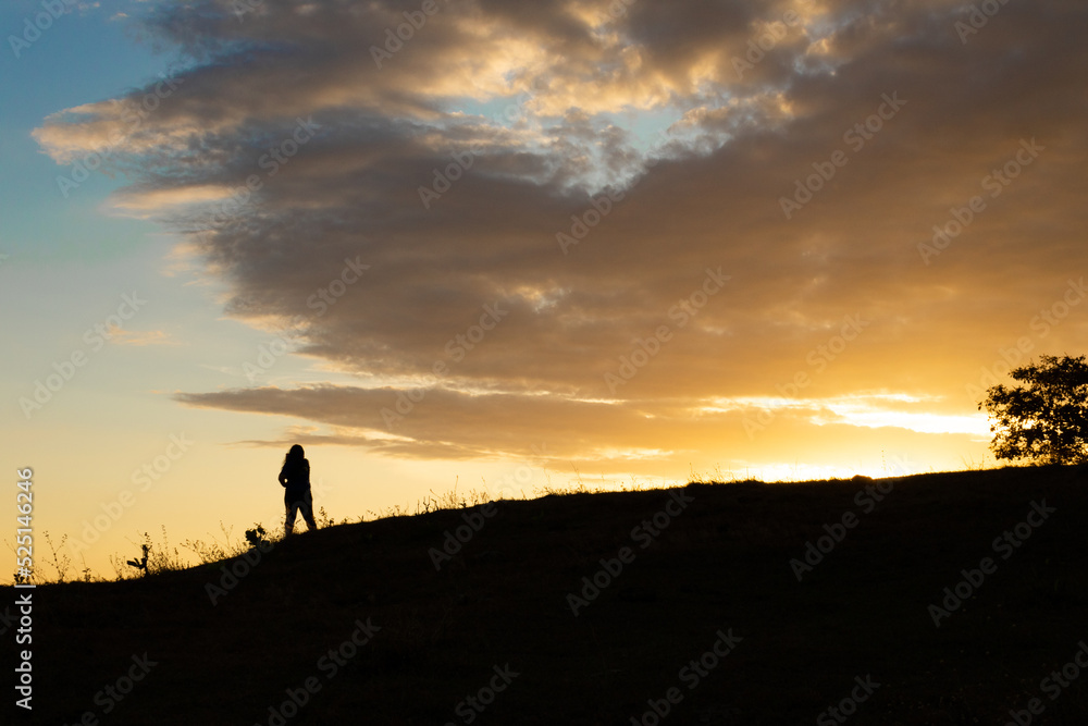 silhouette of a person in the sunset over the mountains