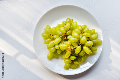 Juicy fresh grapes on a white plate. Delicious grapes washed on a plate.