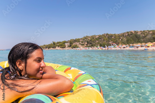 Idyllic summer vacation..A beautiful teenage girl in a bikini relaxes in a sea lagoon on an air mattress. Travel and vacation concept