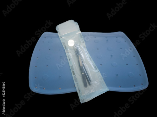 Dentist accessories, sterilized and packaged on a blue tray, all on a black background