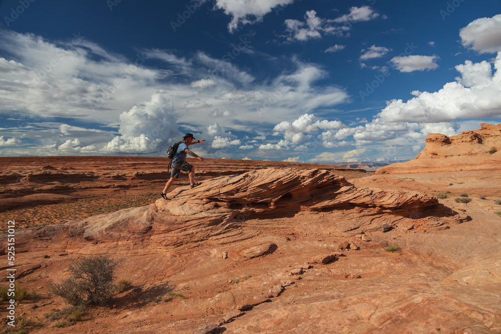 Naklejka premium Hiker walking on rock formations viewed on the Beehive trail in Page, Arizona