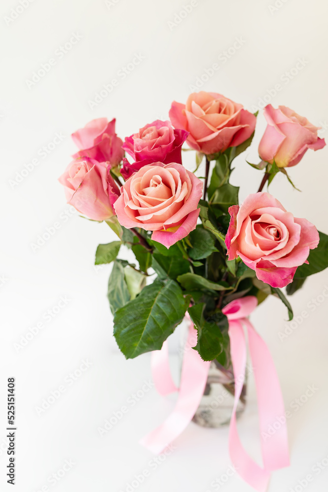 Beautiful bright pink-red roses, flowers in a vase, side view, vertical photo. Flowers for the holiday. Beautiful bright pink-red roses, flowers in a vase, side view, vertical photo. Flowers for the holiday.