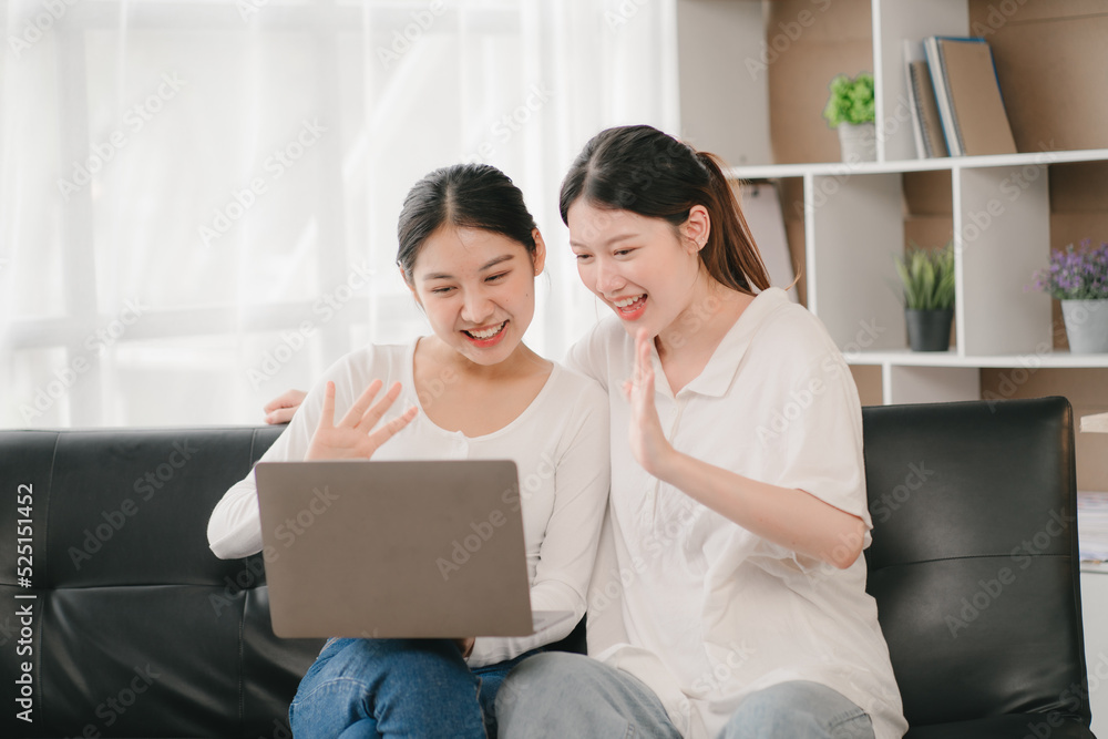Asian woman happy holding laptop phone sitting sofa smiling good mood indoors indoors Asian woman happy holding laptop phone sitting sofa smiling good mood indoors indoors
