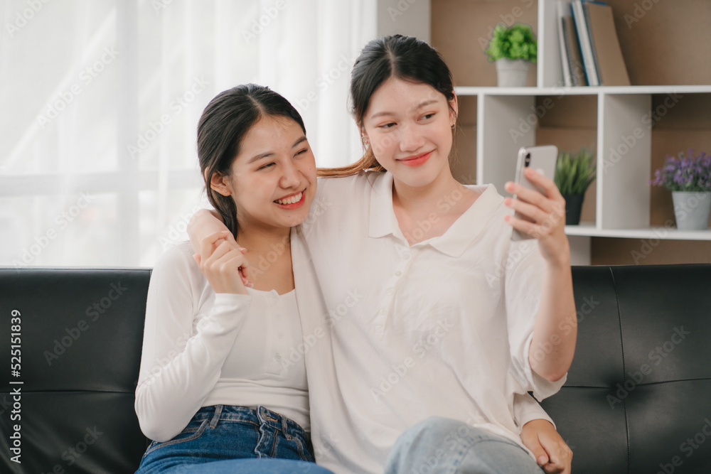 Asian woman happy holding laptop phone sitting sofa smiling good mood indoors indoors Asian woman happy holding laptop phone sitting sofa smiling good mood indoors indoors