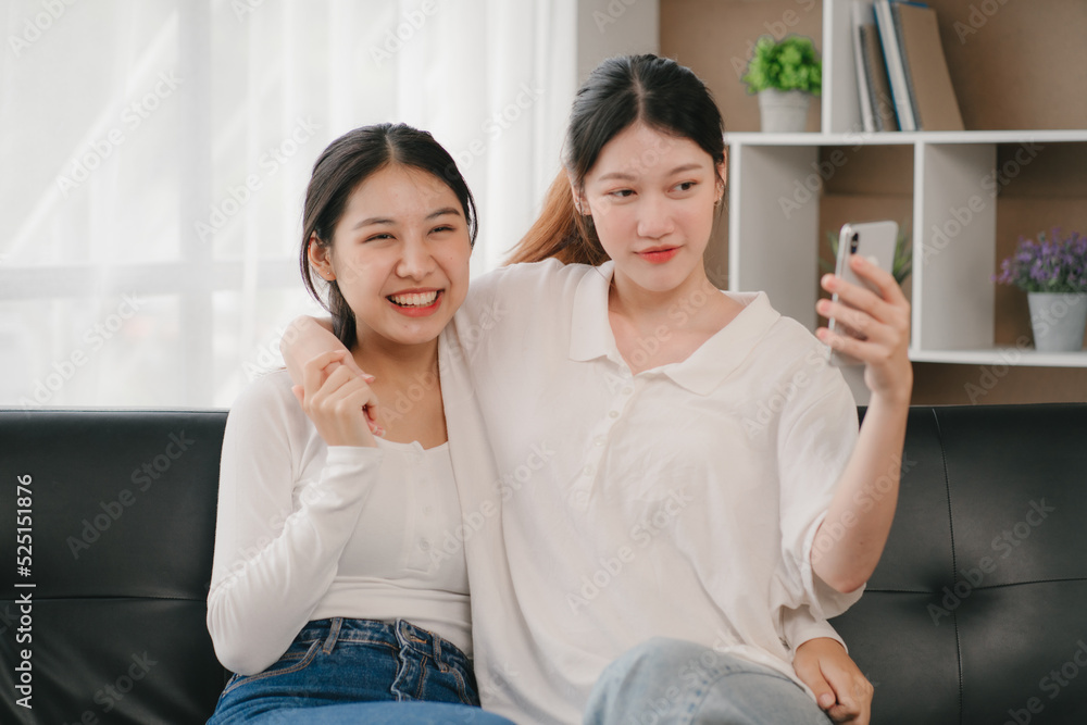 Asian woman happy holding laptop phone sitting sofa smiling good mood indoors indoors Asian woman happy holding laptop phone sitting sofa smiling good mood indoors indoors